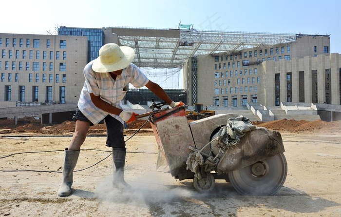 阳光下带着草正在施工的建筑工人图片