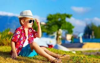 在草地上坐着的小男孩图片