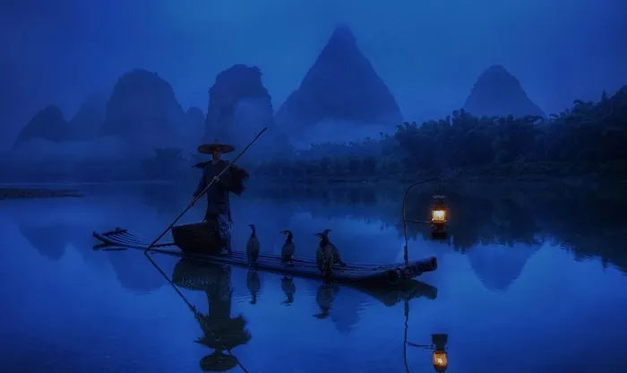 夜色下捕鱼的渔翁图片