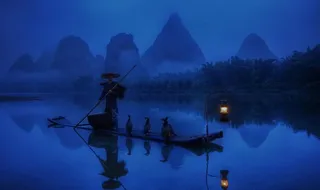 夜色下捕鱼的渔翁图片