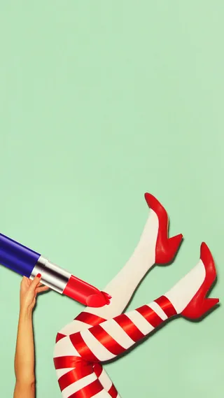 青色背景前的口红高跟鞋