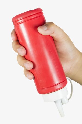 红色塑料瓶子手拿着番茄酱包装实免抠