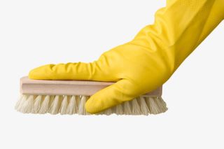 戴着黄色手套压着棕色鞋刷免抠