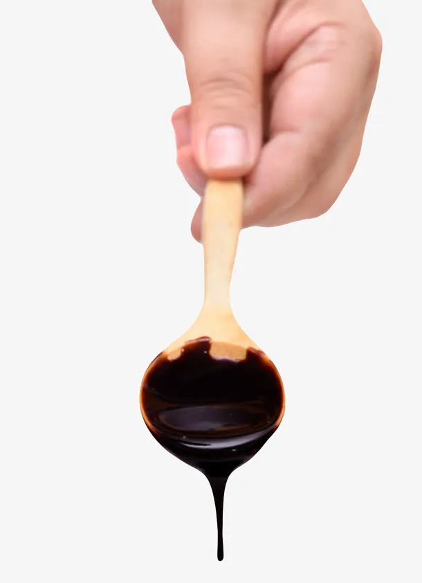 手拿着巧克力酱的木汤勺实物免抠