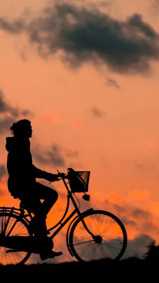 黄昏美女骑车运动剪影背景高清