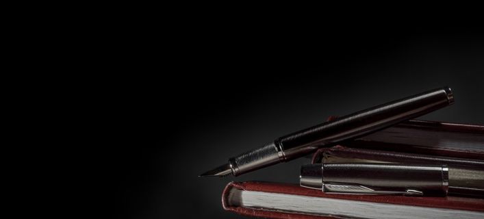 黑色背景一叠本子与钢笔高清