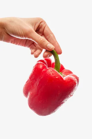 红色美味手捏着带水珠的红灯笼椒免抠