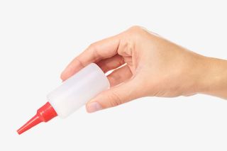 手捏着一瓶透明的强力胶实物免抠