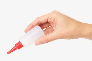 手捏着一瓶透明的强力胶实物免抠