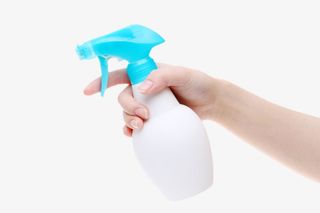 手拿着白色瓶装喷雾清洁用品实物免抠