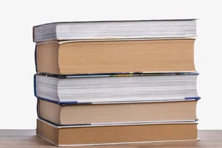 棕色厚实放在书桌上堆起来的书实免抠