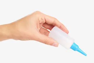 手捏着透明滴液强力胶实物免抠