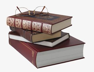 酒红色厚实放着眼镜的堆起来的书免抠
