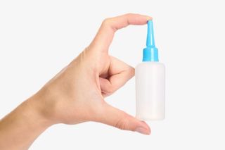 两根手指捏着一瓶强力胶实物免抠