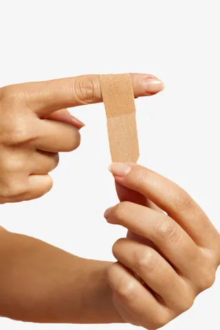 正在为受伤的手指贴着创可贴免抠