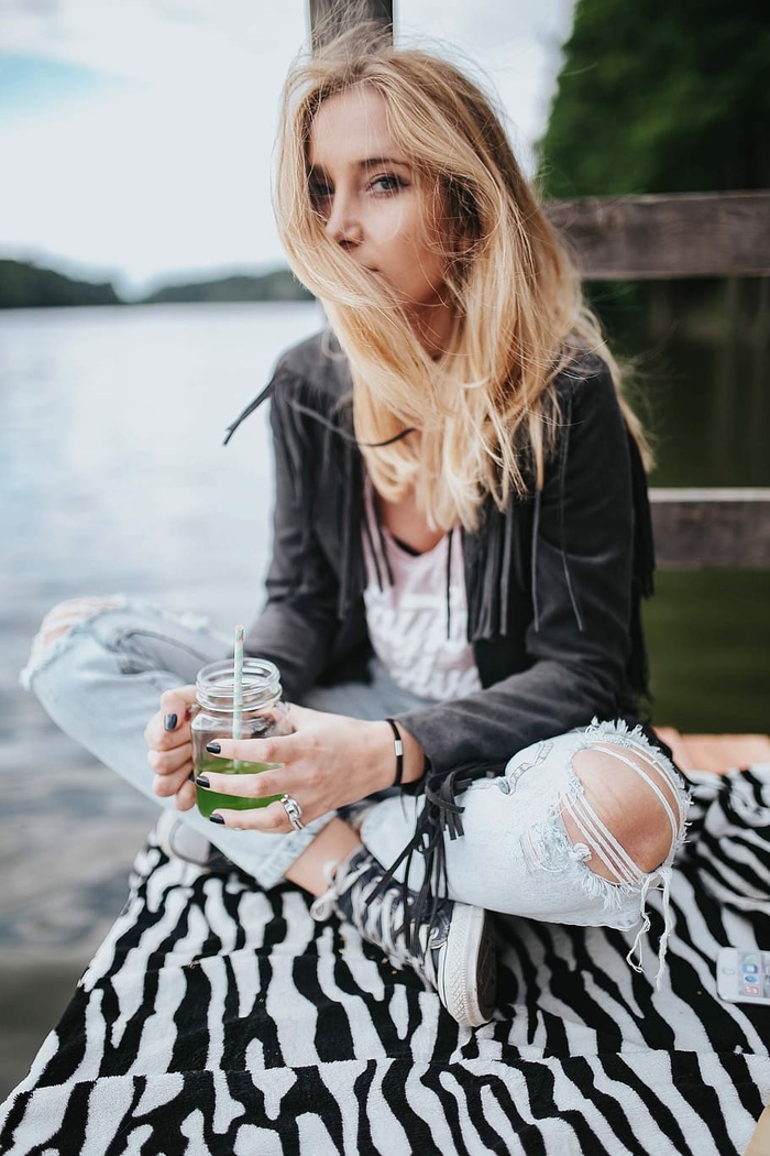 金发女人在木码头吃健康零食