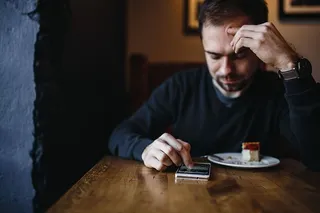 年轻的衣着优雅的男子坐在咖啡馆里