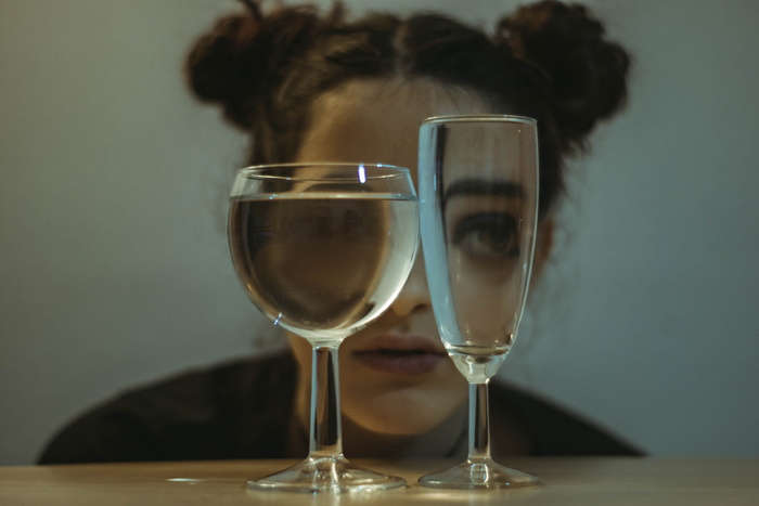 两个透明的酒杯放在靠近女人的桌子上