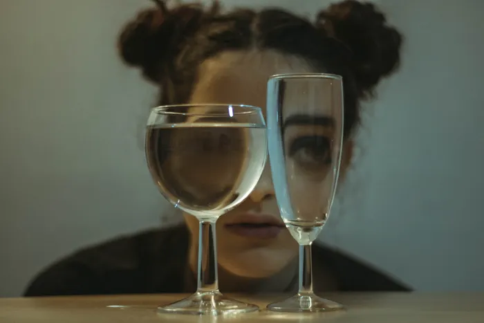 两个透明的酒杯放在靠近女人的桌子上