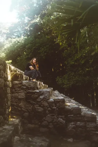 坐在棕色和白色楼梯上的女人