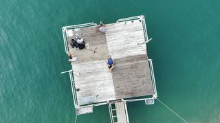 躺在水体棕色木质平台上的人