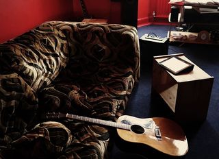 斜靠在棕色天鹅绒沙发上的棕色原声吉他