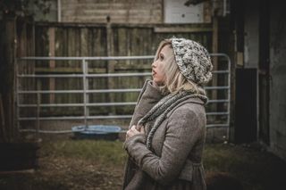 穿着灰色连帽衫和针织帽的女士