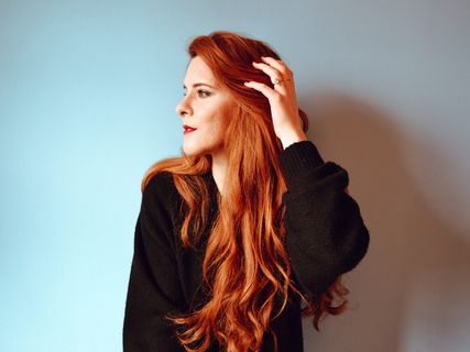 一名身穿黑色夹克的女子从右侧看去