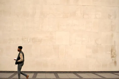 在灰色水泥路面上行走的男子