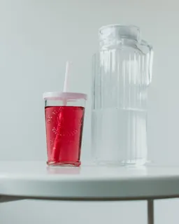 水罐旁装满红色物质的杯子 水罐旁装满红色物质的杯子