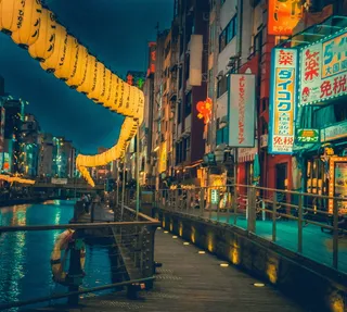 带有棕色木质码头的运河，在夜间被建筑物包围