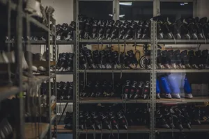 白色房间内灰色金属架上的黑色和蓝色溜冰鞋