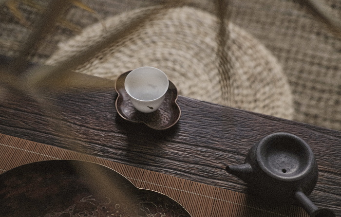 茶壶旁茶托上的白色茶杯
