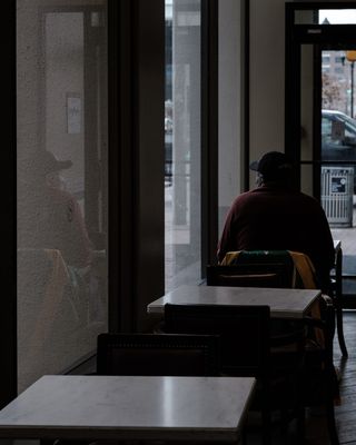 坐在透明玻璃墙旁边的人