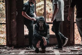 男子戴着防毒面具蹲在地上