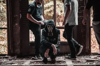 男子戴着防毒面具蹲在地上