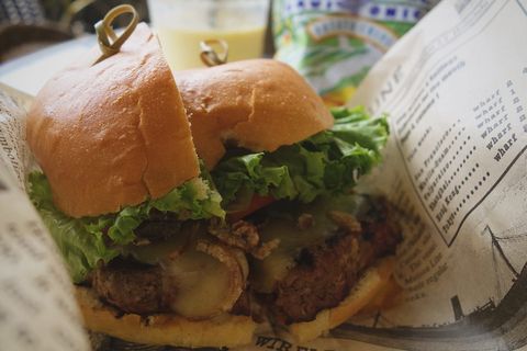 在白纸上把生菜切成两半的汉堡包