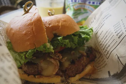 在白纸上把生菜切成两半的汉堡包 在白纸上把生菜切成两半的汉堡包