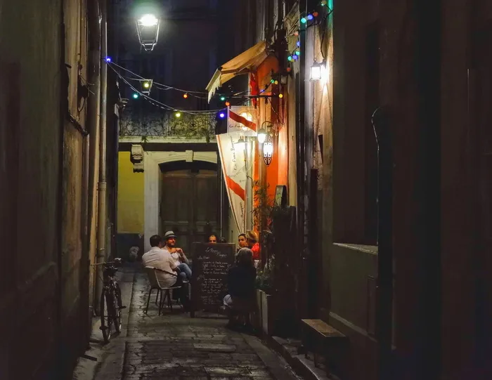 一群人在夜间坐在桌子周围的椅子上