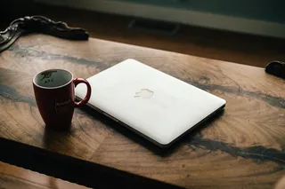红色陶瓷杯旁的银色MacBook