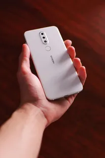 手持白色诺基亚智能手机的人