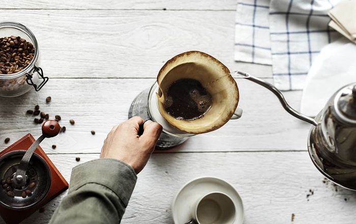 手持白色陶瓷茶杯的人