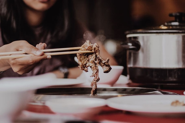 拿米色筷子的女人
