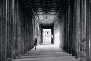 人在柱子附近行走的灰度照片