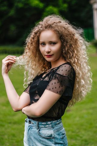 一名女子一边摆姿势一边拿着头发的照片