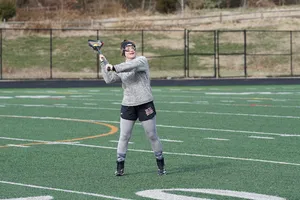 穿着灰色运动衫的女子白天打长曲棍球