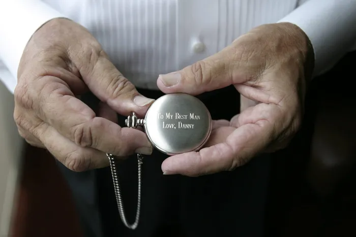 手持银色怀表的人