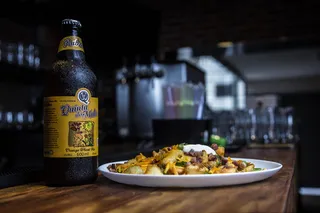 金塔酒瓶在棕色木桌上烹调食物