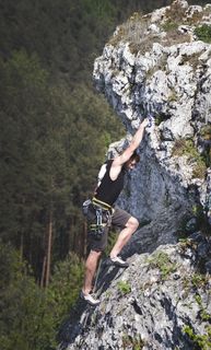 男子身穿黑色背心和棕色短裤攀岩 男子身穿黑色背心和棕色短裤攀岩