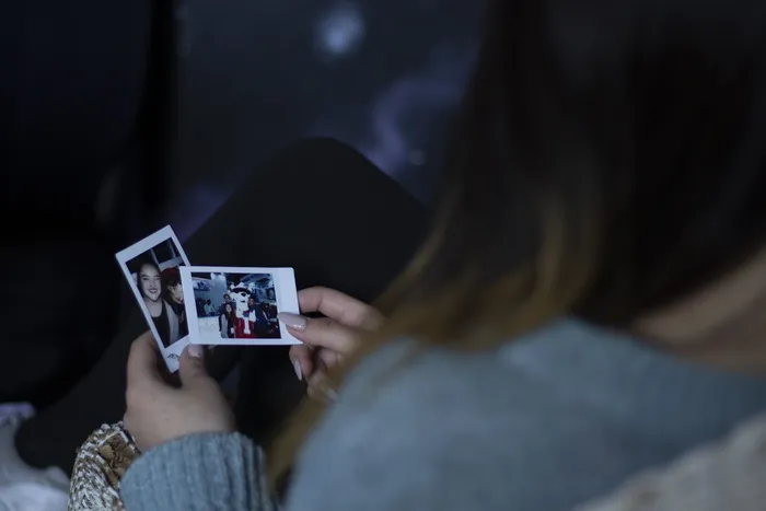 拿着两张照片的女人